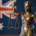 Bronze Lady Justice statue with scales, set against the Australian flag, symbolising fairness and access to justice in Australia.