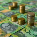 Australian hundred-dollar notes and stacked gold coins representing financial growth, investment, and wealth management in Australia.