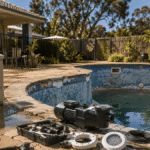 Ageing backyard swimming pool in an Australian home showing worn tiles, faded surfaces, and new energy-efficient pool equipment ready for renovation.